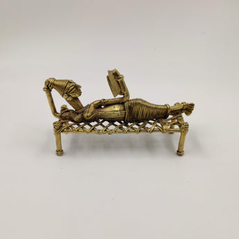 Dokra reclining reading lady on a cot