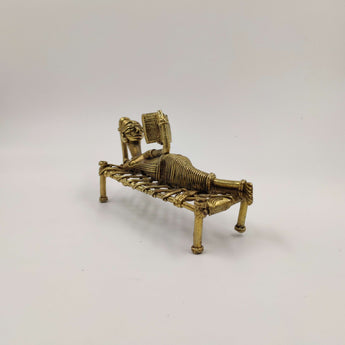Dokra reclining reading lady on a cot